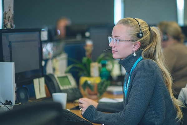 Wessex Water employee sat at her desk with a headset on