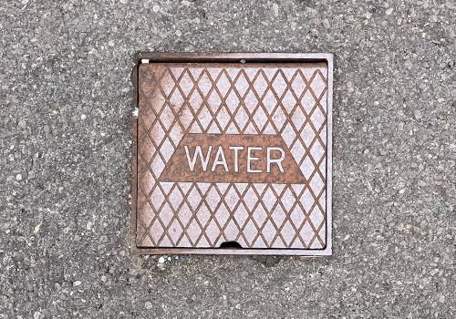External stop tap, under a brown metal cover that has water written on the centre. 