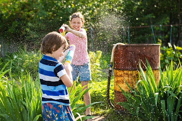 Children having a water fight in a garden
